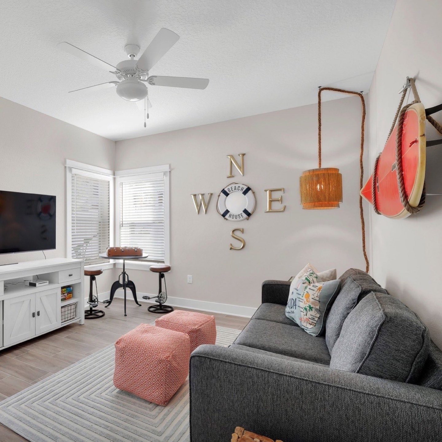 Beach house lounge with a compass rose feature wall, built-in seating and a game table